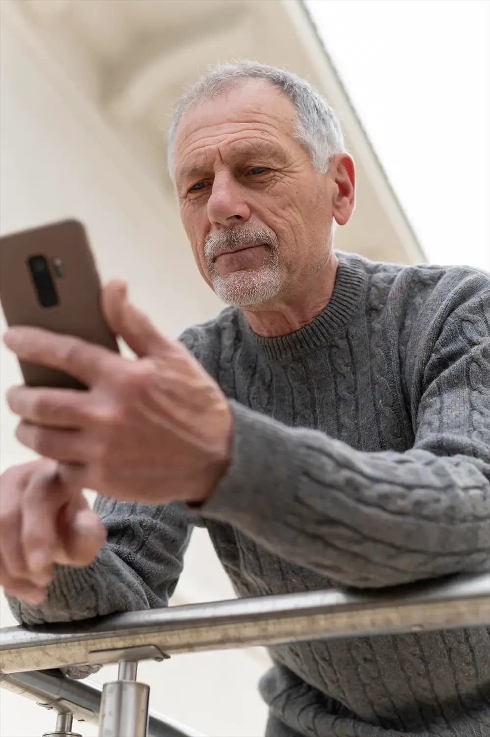 Un domn în vârstă care se uită la telefon